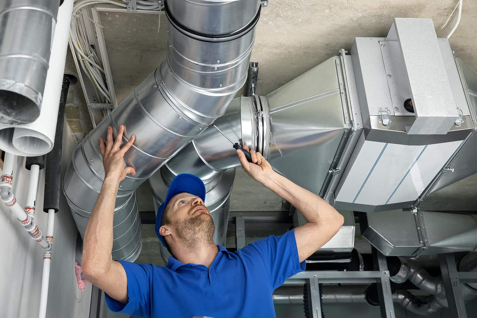 HVAC technician inspecting and repairing air ducts in Riverside