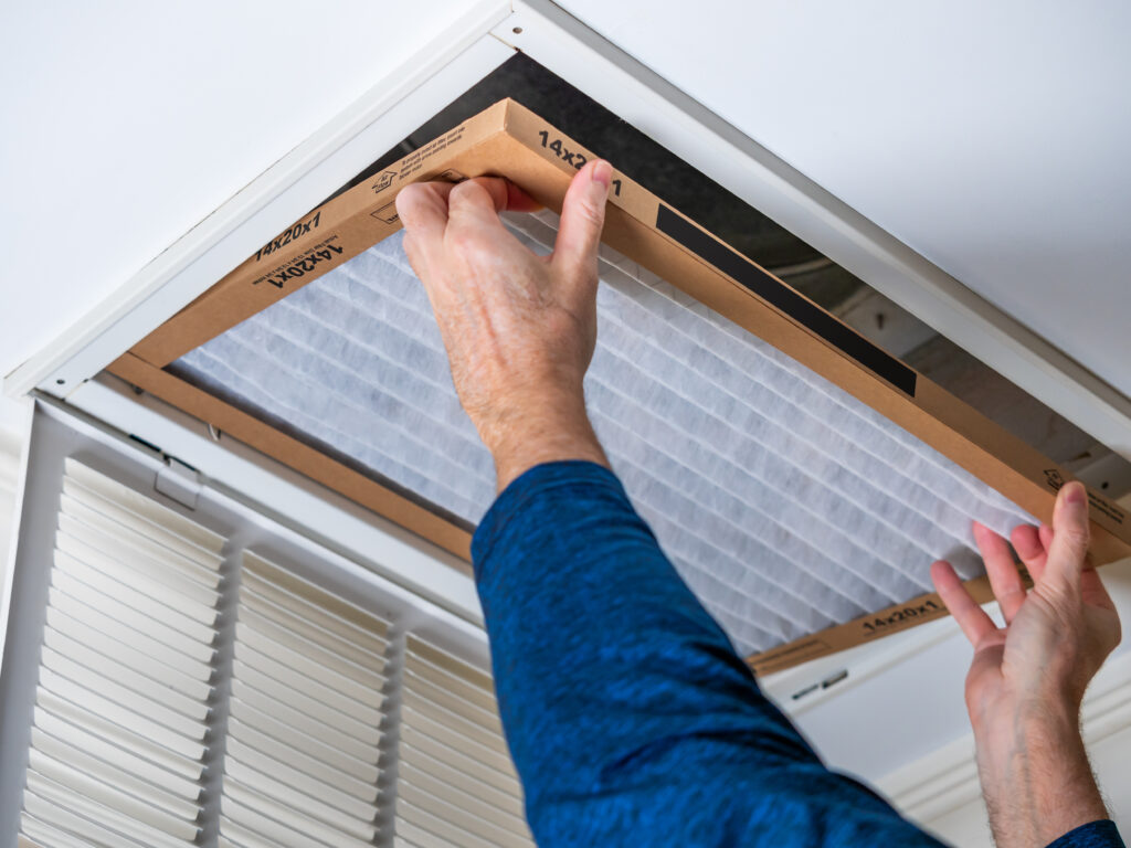 HVAC technician replacing a home air filter in Riverside