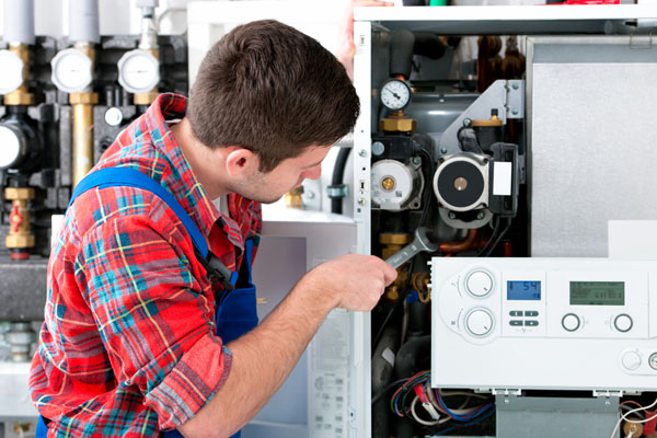 Heating technician repairing boiler controls in Riverside