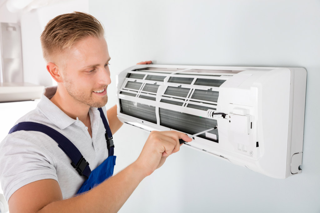 HVAC technician maintaining a ductless air conditioner in Riverside