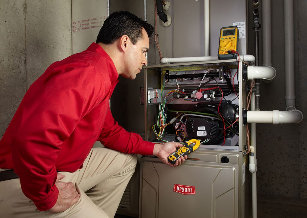 Heating technician diagnosing a furnace repair in Riverside