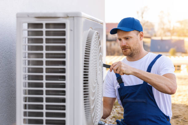 HVAC technician servicing an outdoor air conditioner in Riverside