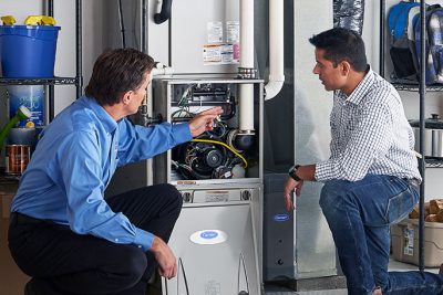 Technician evaluating a furnace for repair or replacement in Riverside