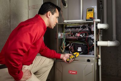 Heating technician diagnosing a furnace repair in Riverside