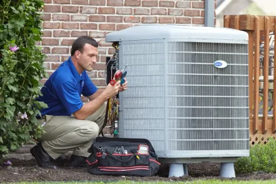 HVAC technician inspecting an outdoor AC unit in Riverside